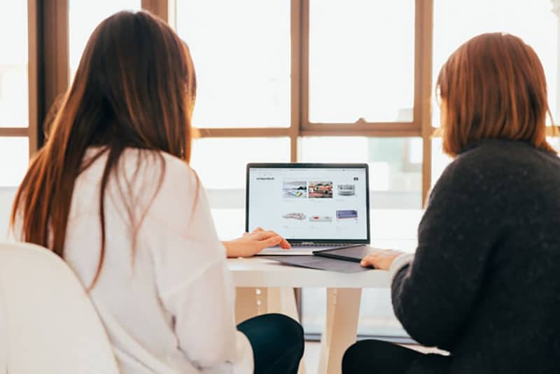 Women analyzing website on computer